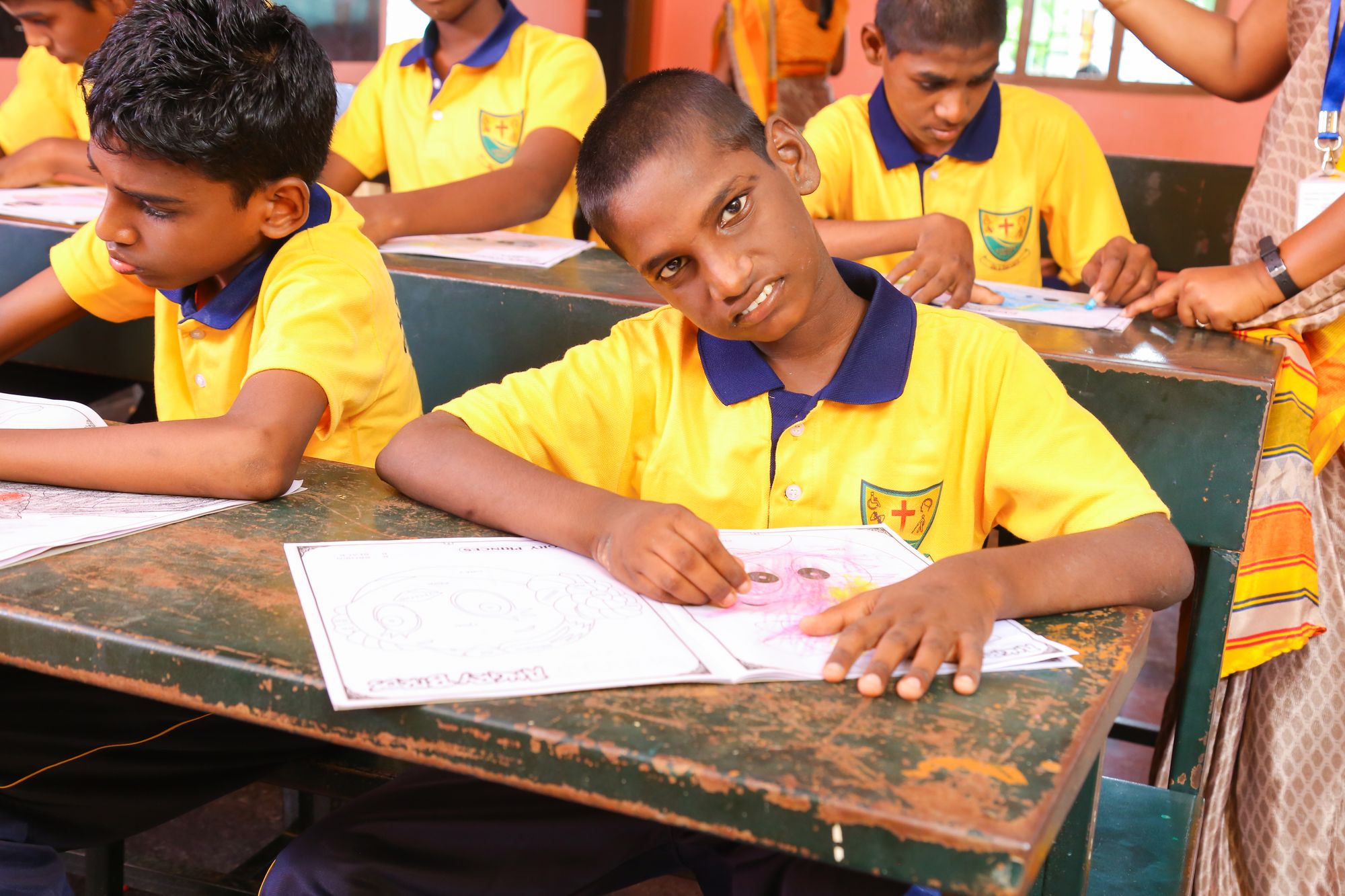 Student colouring at a desk